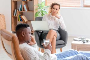 therapist engaged in administering a psychotherapy program to a teenage boy in an office setting