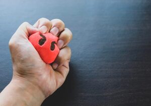 close up image of a fist crushing a stress ball as part of an anger management program