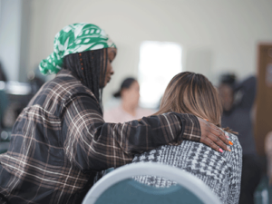 a woman consoles a fellow group member as part of an intensive outpatient program for behavioral health treatment