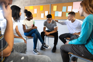 Several young men and women sit together in a circle as part of a group therapy session in a partial hospitalization program