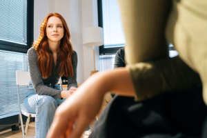 serious young woman in office setting engaged in in individual therapy with her behavioral health therapist