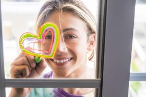 a teen draws a heart on a window, one of many activities to combat depression