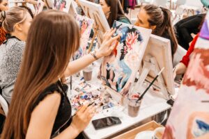 young woman engaged in finger-painting as one of 5 self-care activities to help with anxiety