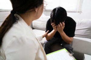therapist explaining to distraught adolescent how dialectical behavior therapy can help PTSD.