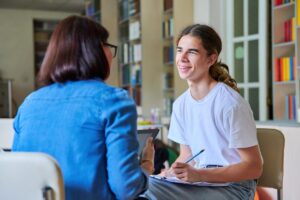 Therapist interviewing adolescent and explaining what do expect in a psychotherapy program
