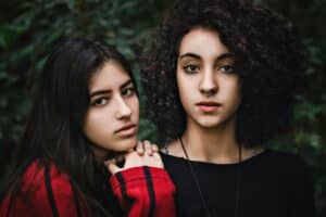 girl leaning on the shoulder of her sister