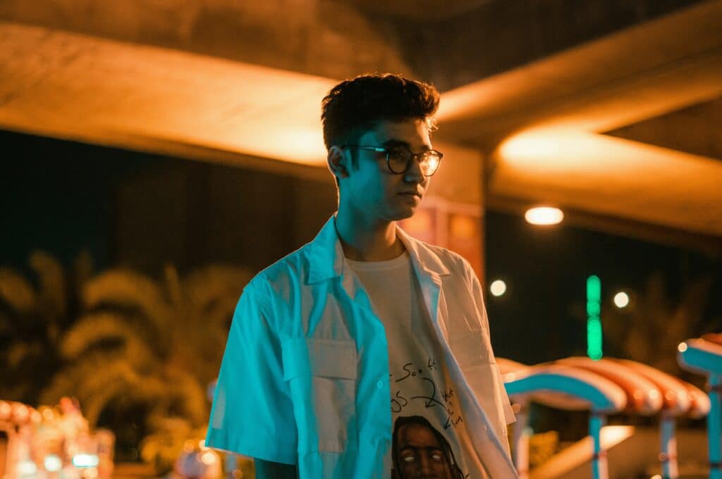 teen boy in glasses standing outside alone at night